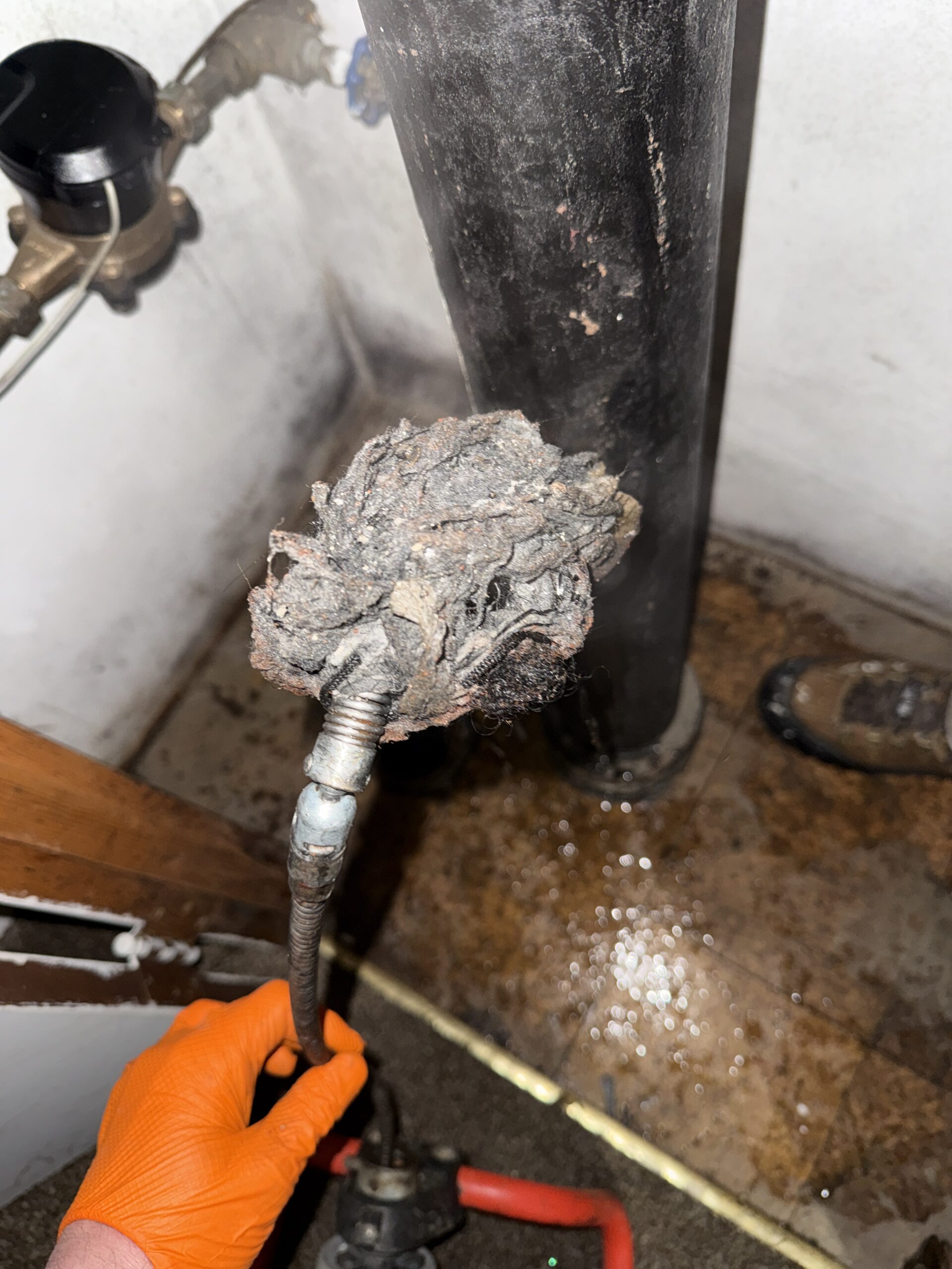 Plumber clearing kitchen drain in busy Harrisburg, PA restaurant after hours