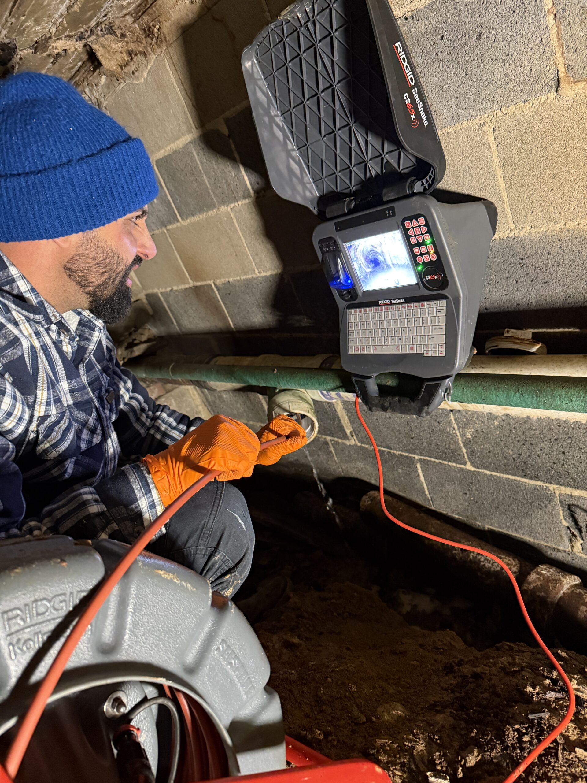 Experienced technician inspecting outdoor storm drain for blockages after heavy rain in Mechanicsburg