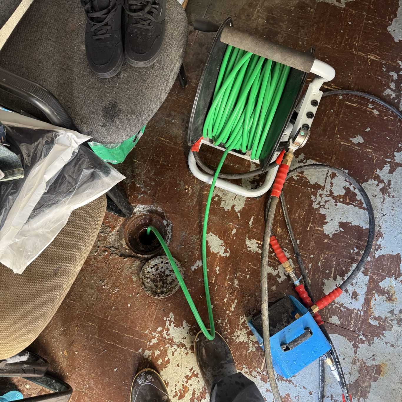 JG Plumbing and Drain Cleaning technician fixing pipes under a kitchen sink in a Shippensburg, PA student apartment