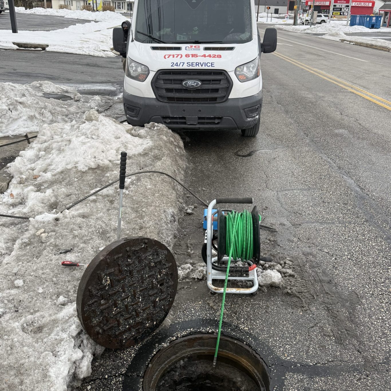 Experienced plumber inspecting stormwater drainage system with advanced camera equipment in Carlisle commercial building