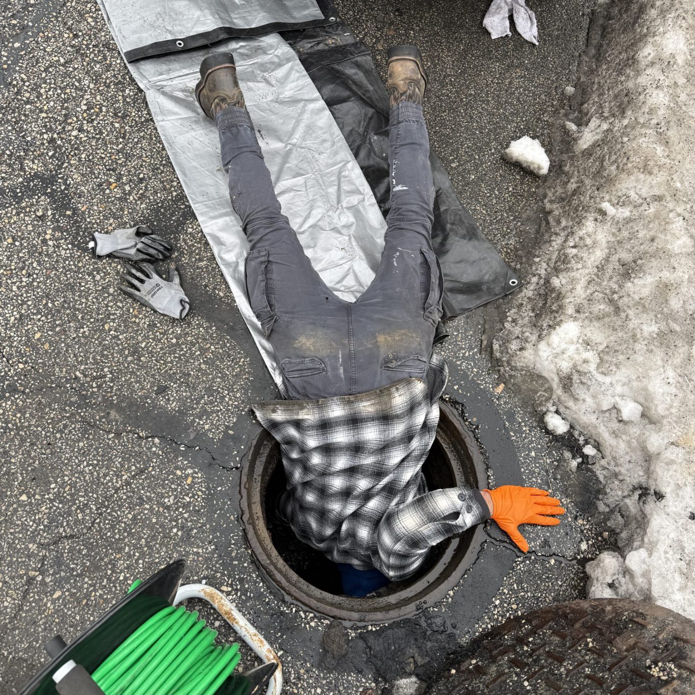 Experienced plumber inspecting main drain line with advanced camera system in Dauphin County property