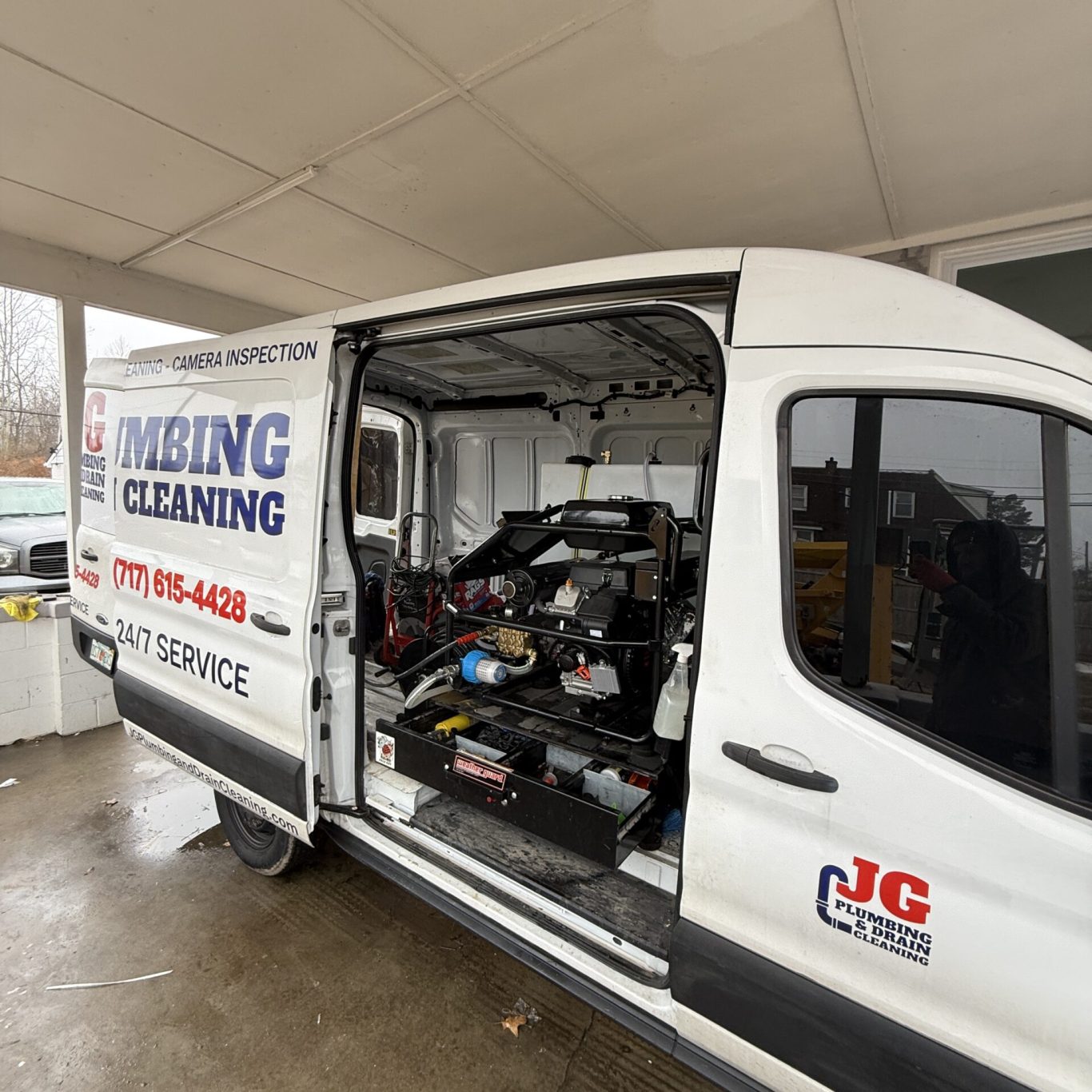 Technician operating drain cleaning equipment at a Cumberland County commercial building after a heavy storm