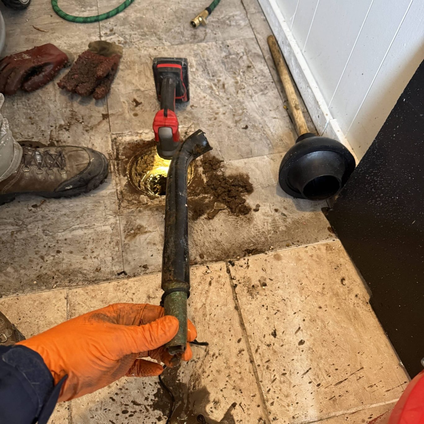 Plumber inspecting and clearing yard drainage system for a local Hershey, PA homeowner after recent flooding