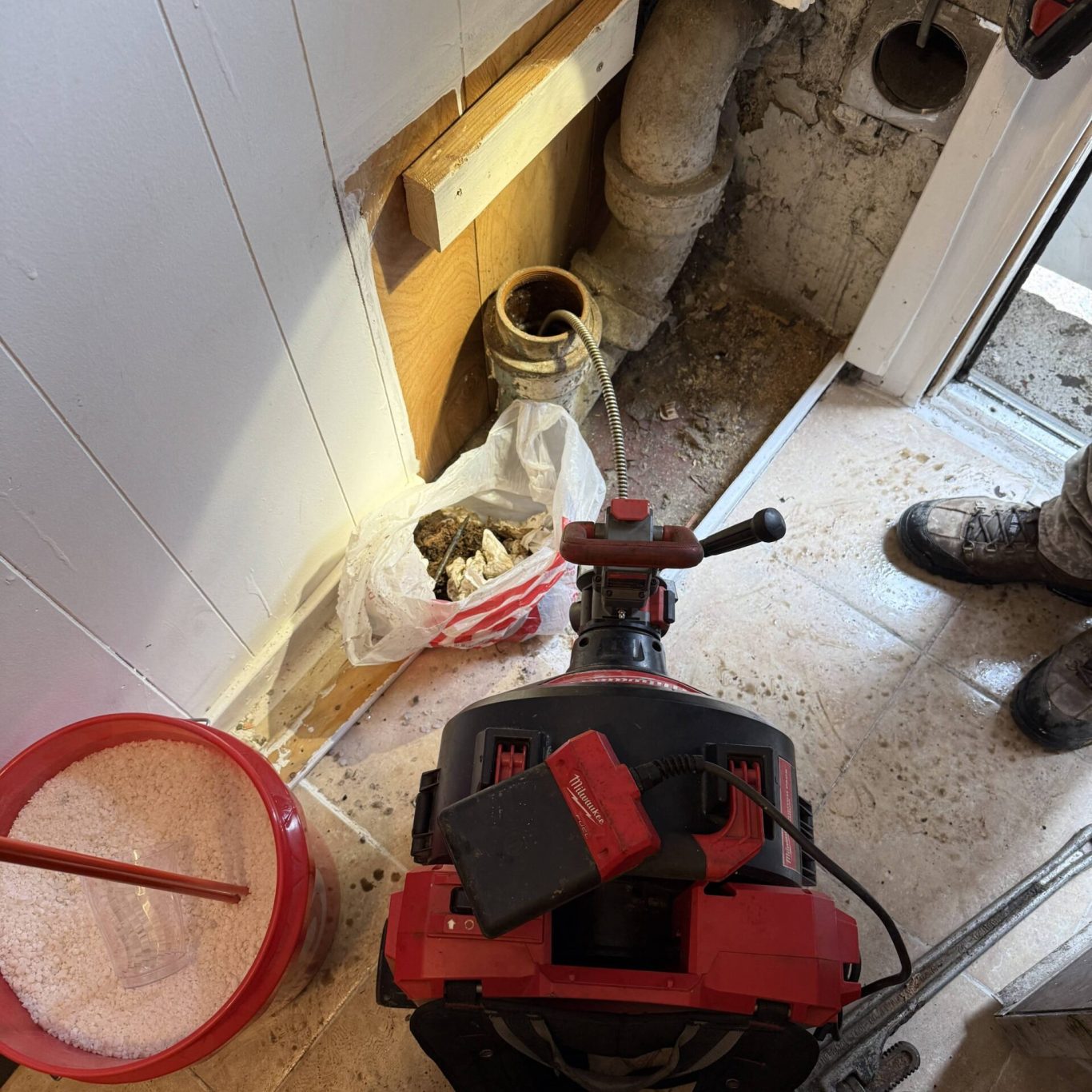 Technician performing sewer line hydro-jetting in a Carlisle, PA residential basement during a scheduled service